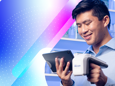 Smiling clinic staff member using a tablet and Alcon barcode scanner in a medical inventory setting