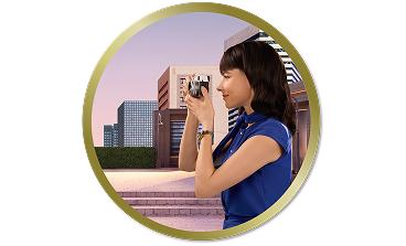 Woman outdoors taking a photo with a camera in front of modern city buildings